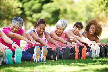 Group of ladies touching their toes while exercising 